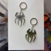 Golden and Silver Spider-Man logo emblem keychain inspired by Marvel superhero design for fans and collectors in Uganda